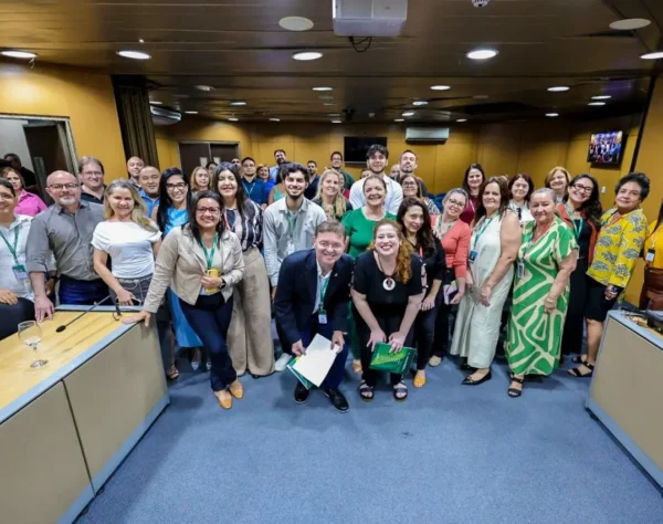 Grupo de aproximadamente 30 participantes, incluindo homens e mulheres, em uma sala da Assembleia Legislativa, posando para uma foto.